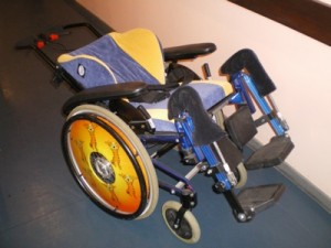 Photo du fauteuil Netti mini de profil lors de l'essai à hacavie en 3 couleurs (bleu, jaune, noir)